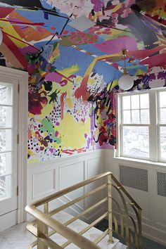 an artisticly painted ceiling in the corner of a room with white doors and windows