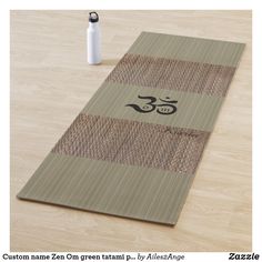 a yoga mat sitting on top of a wooden floor next to a bottle and pen