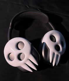 two white masks sitting next to each other on a black surface with a headband