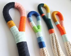 three different colored ropes on a white surface