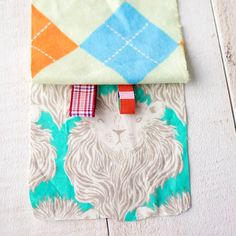 a small pouch with a lion design on the front and an orange, white, blue, and green pattern in the back