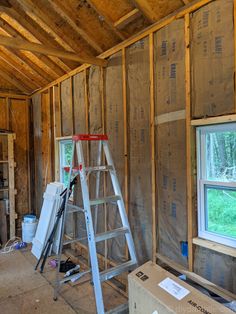 a ladder is in the middle of a room under construction, with windows and insulation