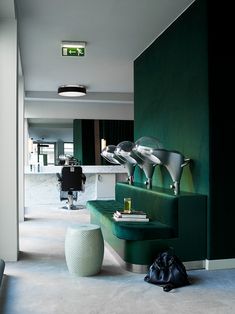 a living room with green walls and white carpeted flooring on the side walk