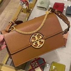 Tory Burch Women's Miller Flap Shoulder Bag Adjustable Removable Shoulder Strap, 13" Drop Top Handle, 5.25" Drop Dimensions: 10.75"W X 3.5"D X 7"H Magnetic Snap Flap Closure Interior Zip Pocket, Interior Slip Pocket Gold-Tone Hardware Mannequin Model Measurements: 5'10" Height, Wearing A Size 4 Or Small Fabric Lining Leather High-end Tan Shoulder Bag With Branded Hardware, High-end Tan Shoulder Bag With Gold-tone Hardware, Tan Shoulder Bag With Gold-tone Hardware For Everyday Luxury, Mannequin Model, Flap Shoulder Bag, Drop Top, Tory Burch Bags, Tory Burch Bag, 7 H