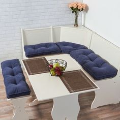 a white table with blue cushions on it