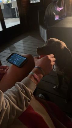 a person holding a cell phone with a dog on the other hand and an apple watch in front of them