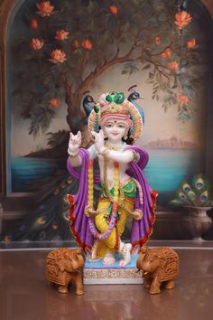 a statue of the god ganesh in front of a painting