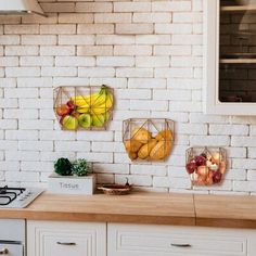 three baskets filled with fruit sitting on top of a kitchen counter