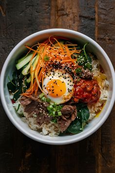 Bibimbap bowl with rice, beef, carrots, cucumbers, spinach, gochujang, and a fried egg, topped with sesame seeds and scallions. Lunch Korean Food, Korean Simple Food, Korean Bimbap Bowls, Bimibap Recipes, Dinner Recipes Korean, Lunch Asian, Foods Korean, Bibimpab Korean