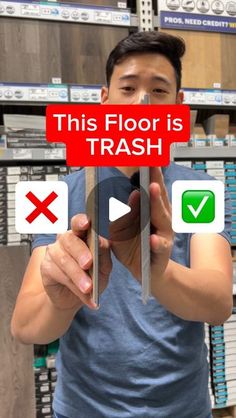 a man holding up a red sign that says this floor is trash with other signs behind him