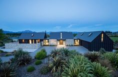 an aerial view of a modern home in the mountains at dusk with blue sky and clouds