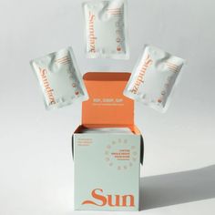 three packets of sun soap sitting on top of each other