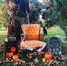 an orange chair sitting on top of a lush green field next to a cemetery with tombstones