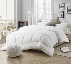 a bed with white comforter and pillows in a room