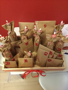 there are many brown bags that have numbers on them and tied with red ribbon around the edges