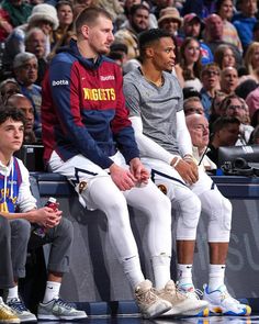 two men sitting on the bench during a basketball game