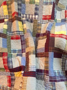 an old quilt with many different colors and patterns on the fabric, as well as squares