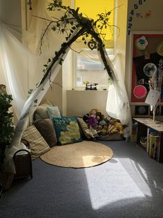 a living room with a couch, rugs and plants in the window sill