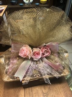 two pink roses are placed on top of a glass box with netting around the edges