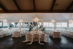 a room with tables and chairs covered in white linens