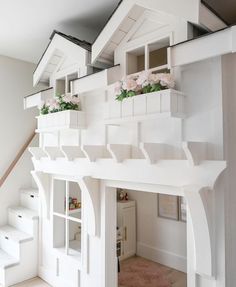 there is a dollhouse with flowers in the window and stairs leading up to it