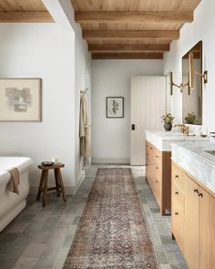 a bathroom with wood ceiling and tile flooring