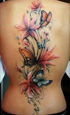 the back of a woman's body with butterflies on it and flowers in the middle