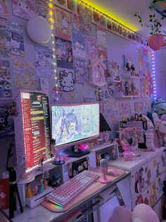 a desk with a computer monitor and keyboard on it in front of a wall full of hello kitty pictures