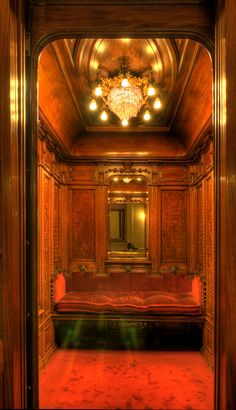 the inside of a train car with red carpet and wood paneling on the walls