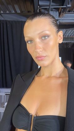 a woman in a black top and jacket posing for the camera at a fashion show