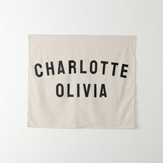 a white wall hanging with the words charlotte and oliva printed in black on it