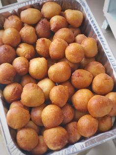 a metal pan filled with lots of small yellow balls on top of a countertop