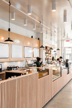 people are sitting at the counter in a restaurant with wood paneling on the walls