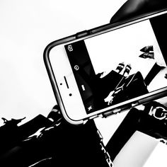 a black and white photo of a person holding a cell phone in their hand,