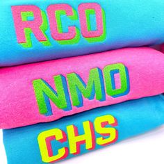 three blue and pink pillows with the words rco nmo chs printed on them