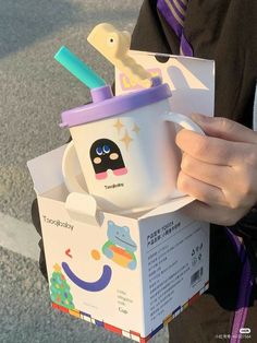 a person holding a box with a cup in it