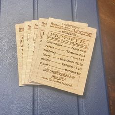 three wooden tickets sitting on top of a blue suitcase