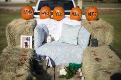 pumpkins are placed on hay bales in the back of a pickup truck,