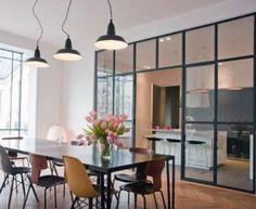 a dining room table with chairs and flowers in the vase on the table next to it