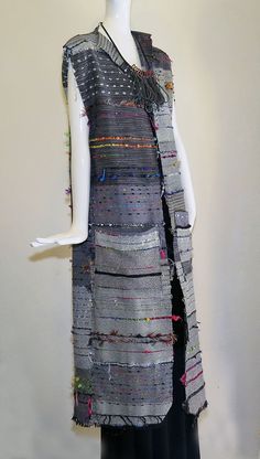 a mannequin wearing a dress made out of fabric and beads on it's sides