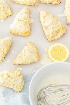 lemon scones with icing next to a bowl of yogurt and a whisk