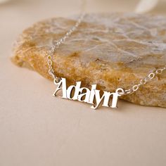 Discover the luxurious charm of the Malibu Name Necklace! Handcrafted with love and attention-to-detail, this gorgeous necklace is the perfect way to show off your name with style. Layer with your favorite necklaces for a boho glam look. NECKLACE FEATURES Choice of Finish: 18k gold plating over sterling silver or Sterling Silver handcrafted custom name pendant. Choice of Size: Small (approx. 3/4 inch) or Large (approx. 1.25 inches) Gold filled or sterling silver cable chain. All necklace finding Trendy Adjustable Silver Name Necklace, Trendy Personalized Silver Necklaces, Trendy Silver Necklaces For Personalized Gifts, Trendy Silver Necklace For Personalized Gift, Trendy Silver Jewelry With Custom Name, Trendy Personalized Sterling Silver Jewelry, Trendy Custom Name Silver Jewelry, Trendy Name Necklace Pendant Gift, Custom Name Silver Charm Necklaces