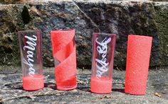 three red vases sitting on top of a rock next to each other with graffiti written on them