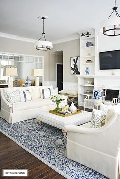 a living room filled with furniture and a flat screen tv mounted on the wall over a fireplace