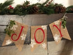 a burlock banner with the word joy on it hanging from a mantel