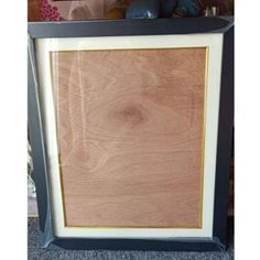 a wooden frame sitting on top of a carpeted floor next to a stuffed animal