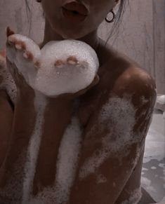 a woman is covered in foam and holding a snowball