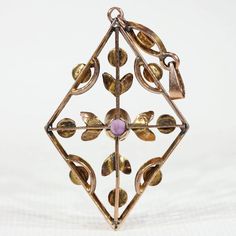 During the Edwardian era, feminine motifs with delicate yet understated designs were considered en vogue. Natural pearls, amethysts, peridots, aquamarines, and other semi-precious stones were worn by affluent women to complement the trend of donning white silk and lace. This jewelry movement differed from the larger and dark colored jewels of the later Victorian era, it was a fresh and welcome change that breathed life back into fashion. This pendant would have been incredibly stylish for its ti Antique Yellow Gold Jewelry With Rose Cut Diamonds, Art Nouveau Rose Gold Jewelry As Gift, Art Nouveau Rose Gold Jewelry Gift, Art Nouveau Rose Gold Jewelry As A Gift, Art Nouveau Rose Gold Jewelry For Gift, Art Nouveau Yellow Gold Jewelry With 17 Jewels, Rose Gold Art Nouveau Jewelry For Gift, Rose Gold Art Deco Jewelry With Rose Cut Diamonds, Art Deco Rose Gold Jewelry With Rose Cut Diamonds