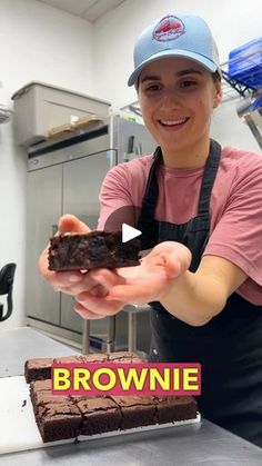 a woman holding a piece of brownie in her hands