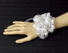 You can't go wrong with white and silver! It will match everything! The silver sparkly balls along with the pearl surrounded in tiny rhinestones make this wrist corsage stunning!The ribbon is sheer and white with a silver stripe. There is also metallic silver ribbon.You can choose elastic wristband, silver rhinestone bracelet or white pearl bracelet.Another listing shows this same corsage with light blue flowers. It can be customized to many different colors. Message me to find out if I have you White Party Bracelets With Rhinestones, White Rhinestone Bracelets For Party, White Ribbon Jewelry For Party, Prom Corsage And Boutonniere, Light Blue Ribbon, Prom Corsage, Rhinestone Rose, Corsage And Boutonniere, White Pearl Bracelet